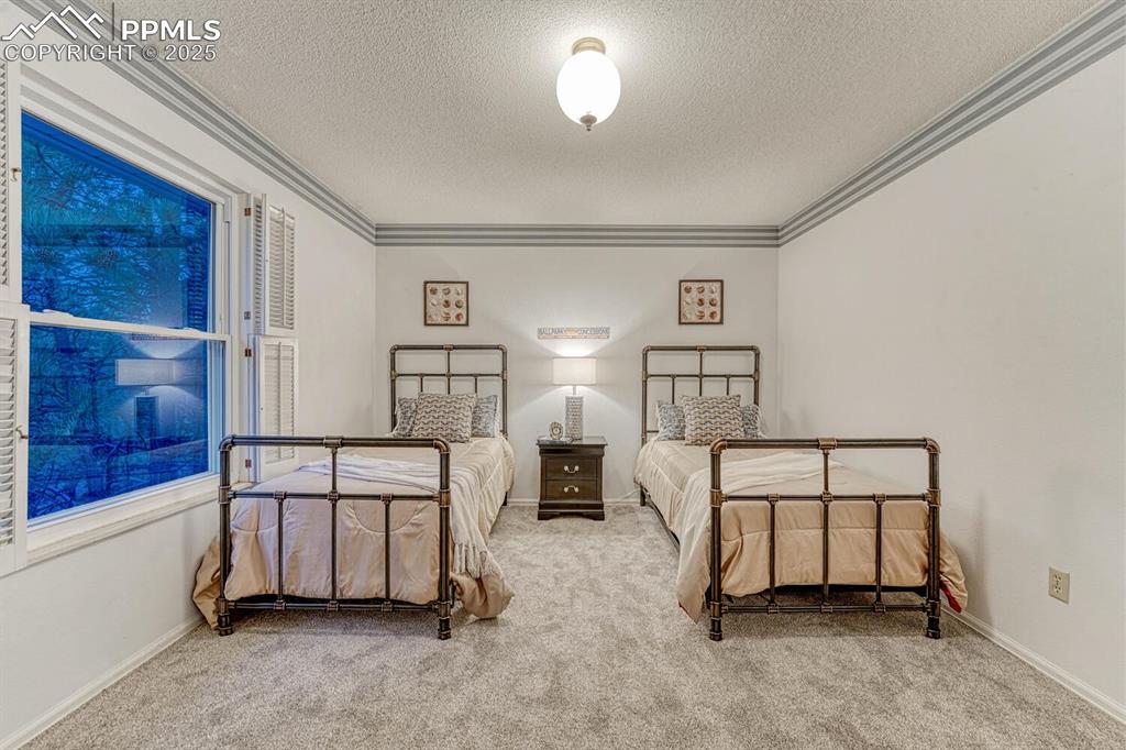 Upper Level Bedroom #2 has neutral carpet and crown molding.