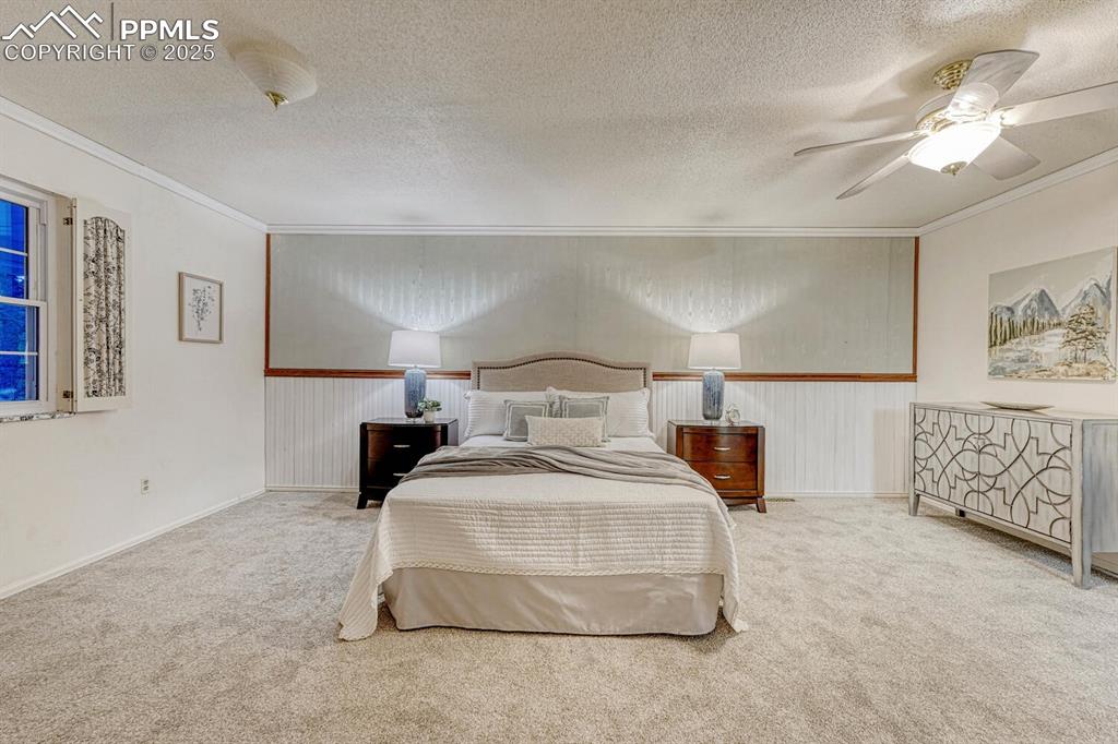 The large, upper level Primary Bedroom is a private retreat with neutral carpet and a lighted ceiling fan.
