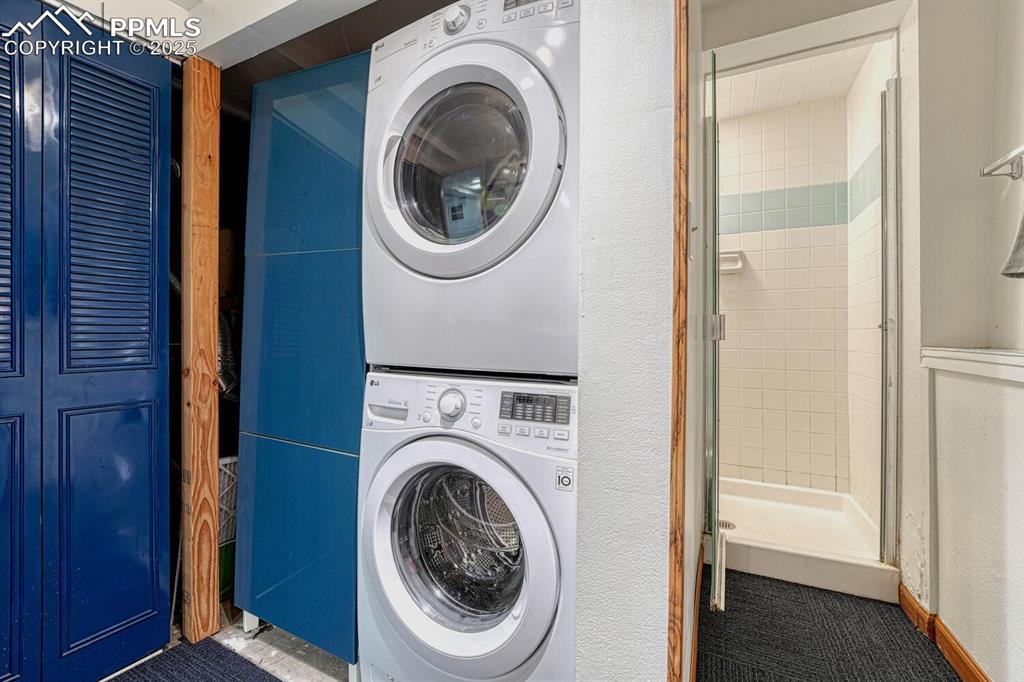 Stackable washer and dryer and tiled shower in the Basement Bathroom.