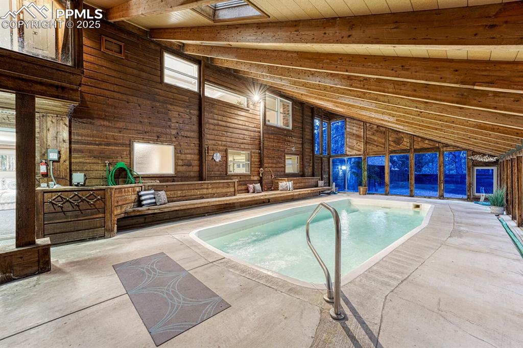 Indoor pool and hot tub room with built in seating.