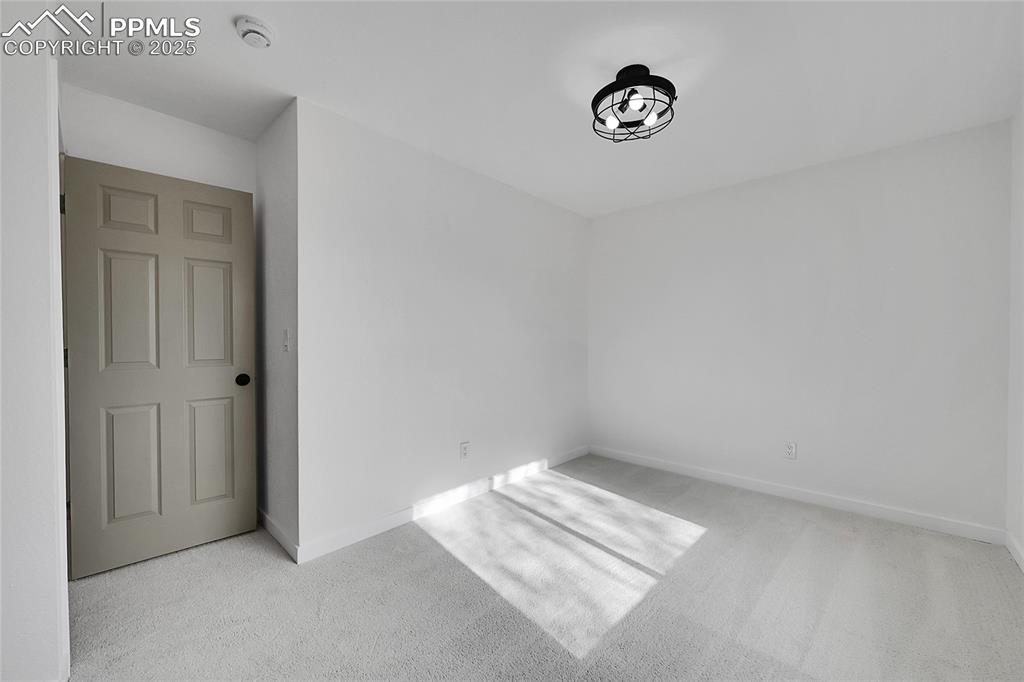 Spare room featuring light colored carpet and baseboards