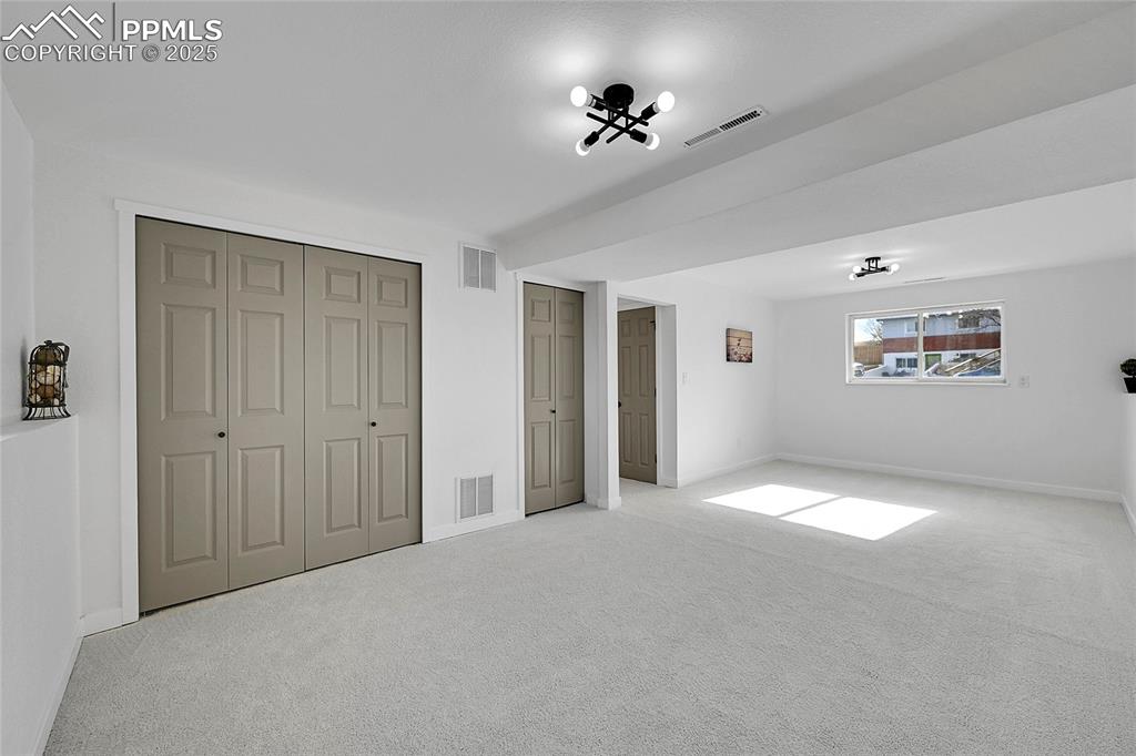 Unfurnished bedroom featuring carpet flooring and multiple closets