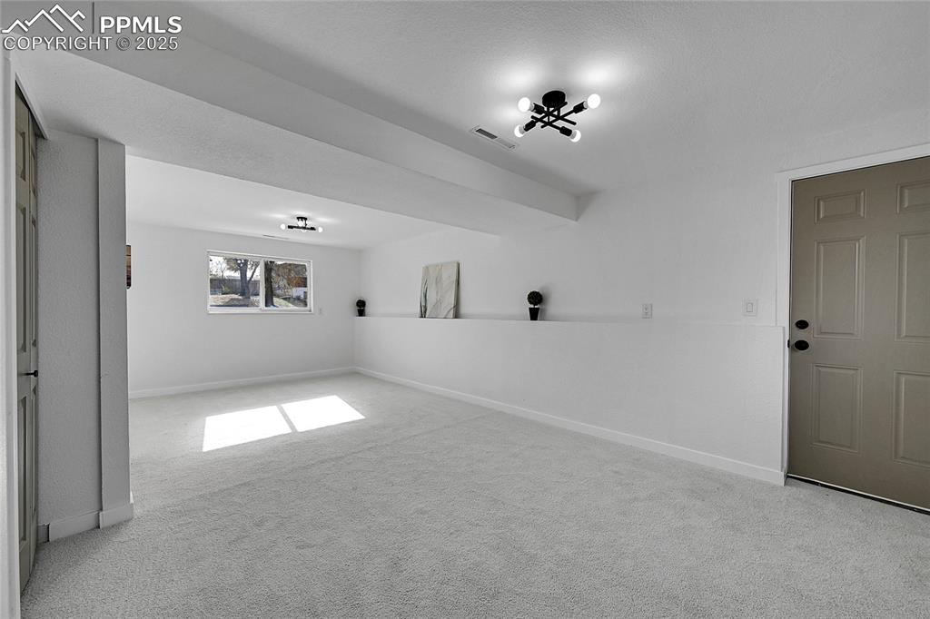 Unfurnished room with light carpet and baseboards