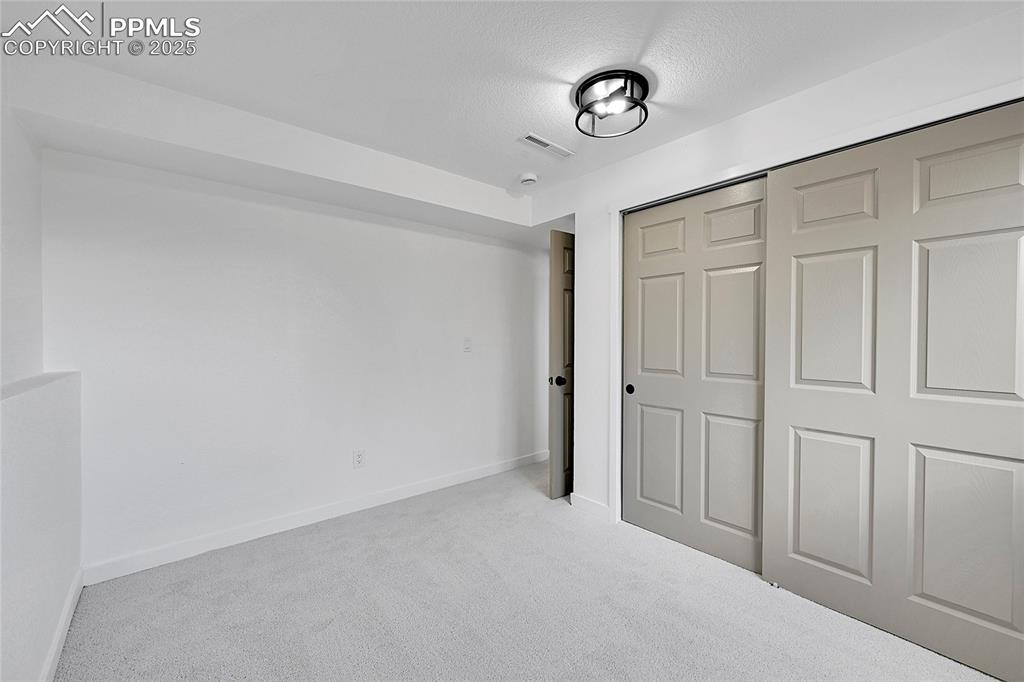 Unfurnished bedroom with carpet floors, a closet, and a textured ceiling