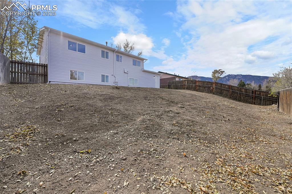 Back of property with a fenced backyard and a mountain view