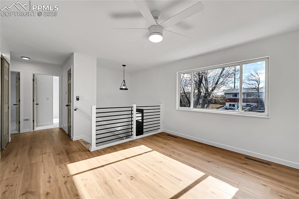 Unfurnished room featuring light wood-type flooring and ceiling fan