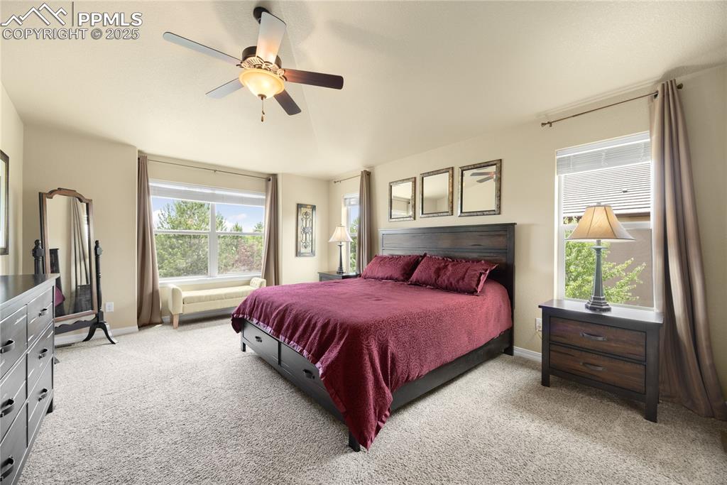 Primary Bedroom with light carpet and a ceiling fan