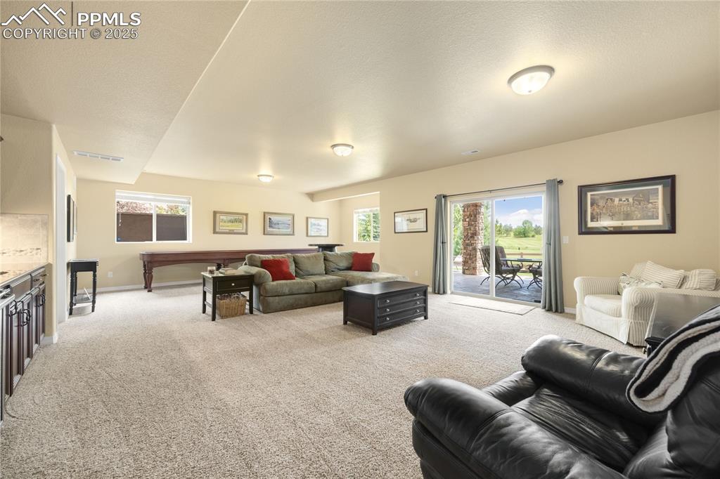Basement Living area with light carpet and baseboards