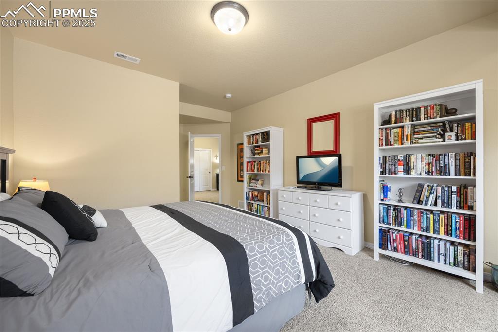 Basement Bedroom with light carpet and baseboards