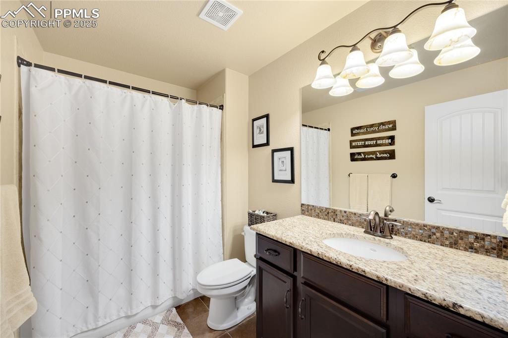 Full bath featuring vanity, tile floors, and shower
