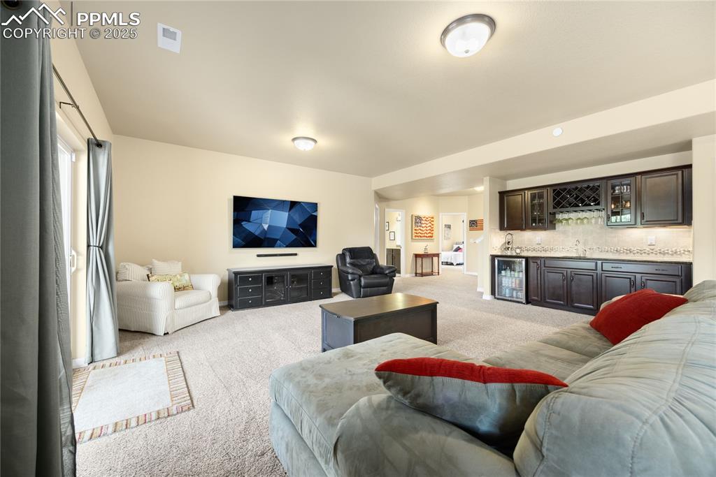 Living room featuring light carpet, wet bar, and wine cooler