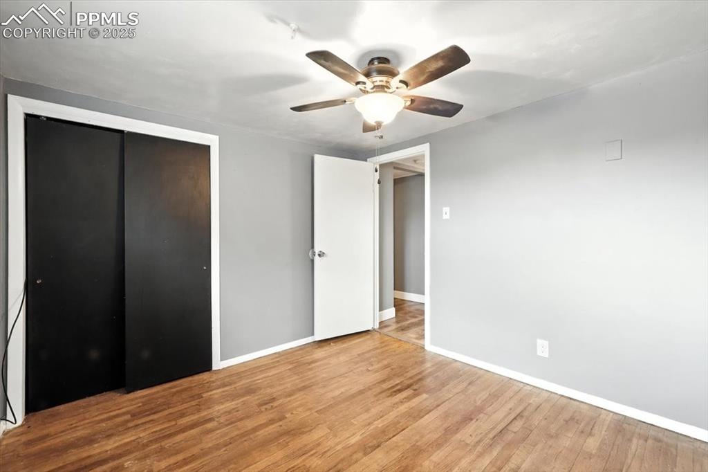 Unfurnished bedroom with wood finished floors, a closet, and ceiling fan
