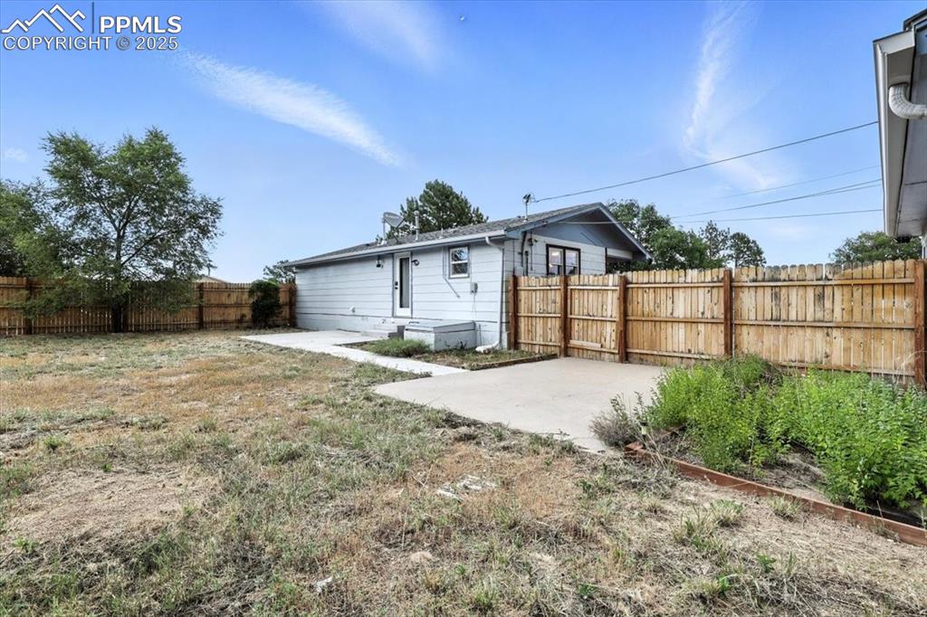 Rear view of house featuring a patio area and a fenced backyard