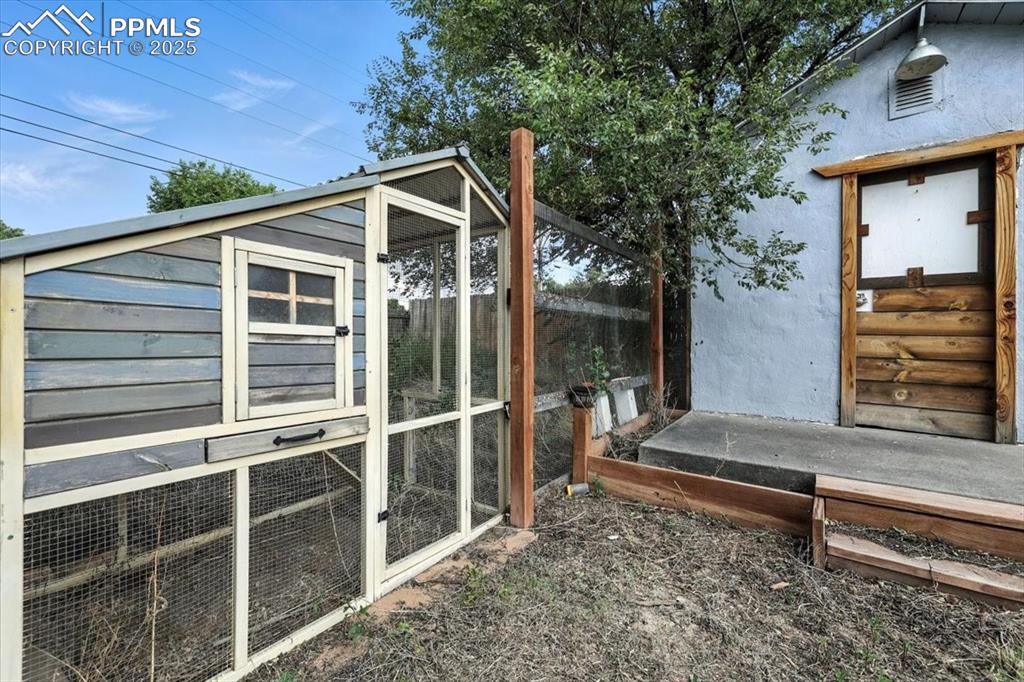 View of side of property with exterior structure, an outbuilding, and stucco siding