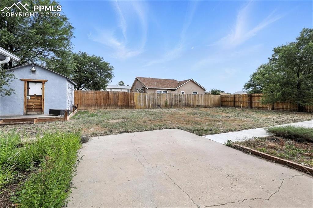 Fenced backyard with a patio area and an outbuilding