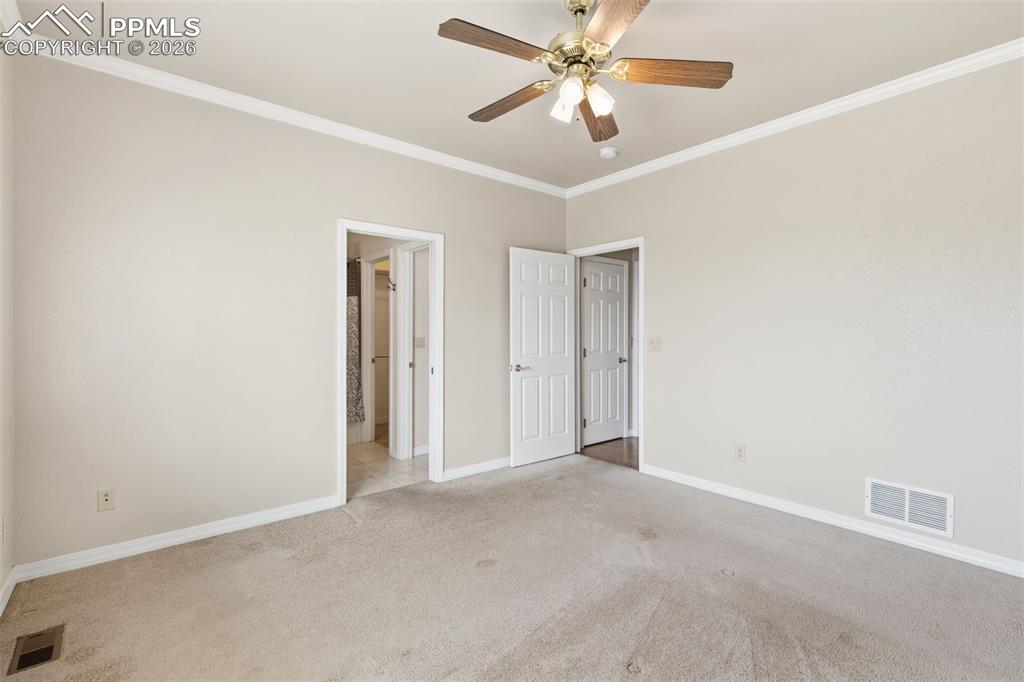 Unfurnished bedroom featuring crown molding, carpet floors, and ceiling fan