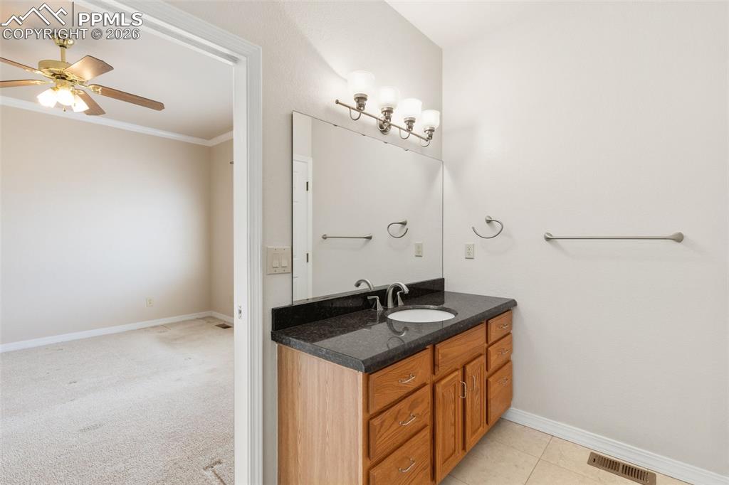 Bathroom with vanity, a ceiling fan, ornamental molding, and light colored carpet