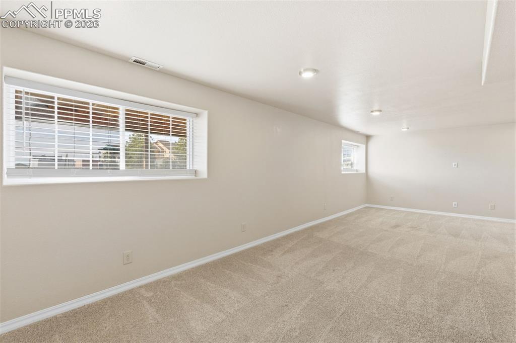 Empty room featuring baseboards and light carpet