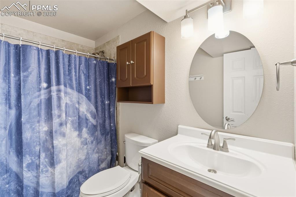Bathroom featuring vanity, a textured wall, and a shower with curtain