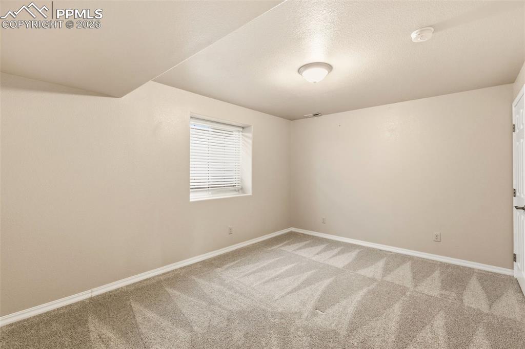 Spare room featuring baseboards and light colored carpet