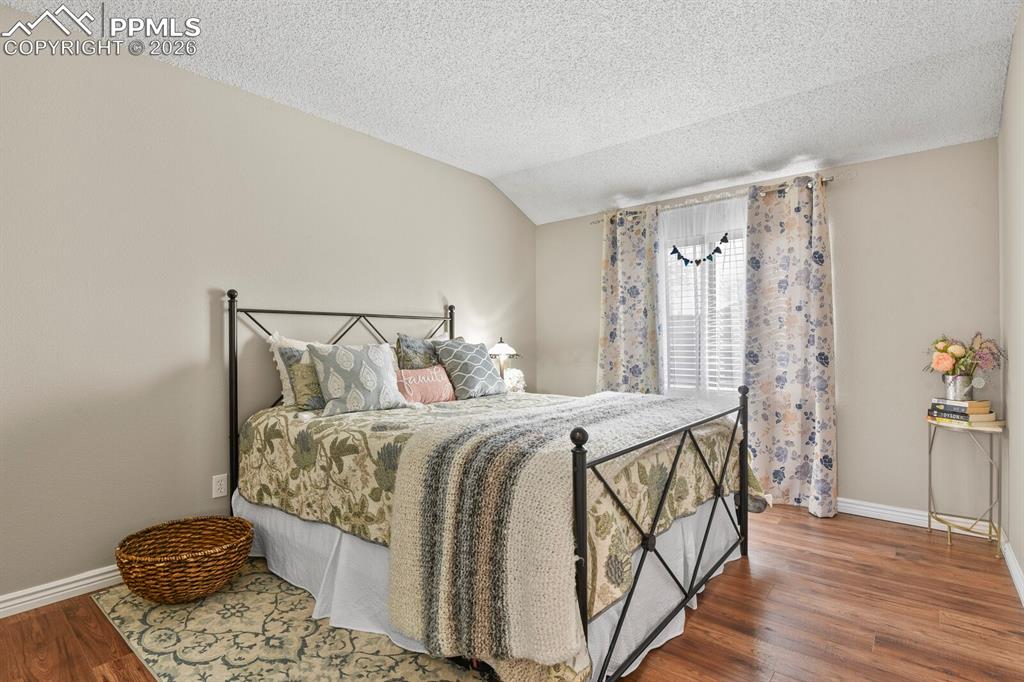 Bedroom with baseboards and dark wood-style floors