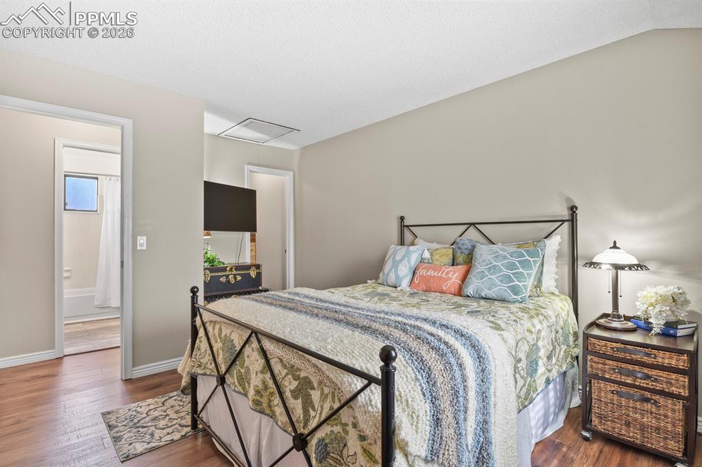 Bedroom with dark wood finished floors and baseboards
