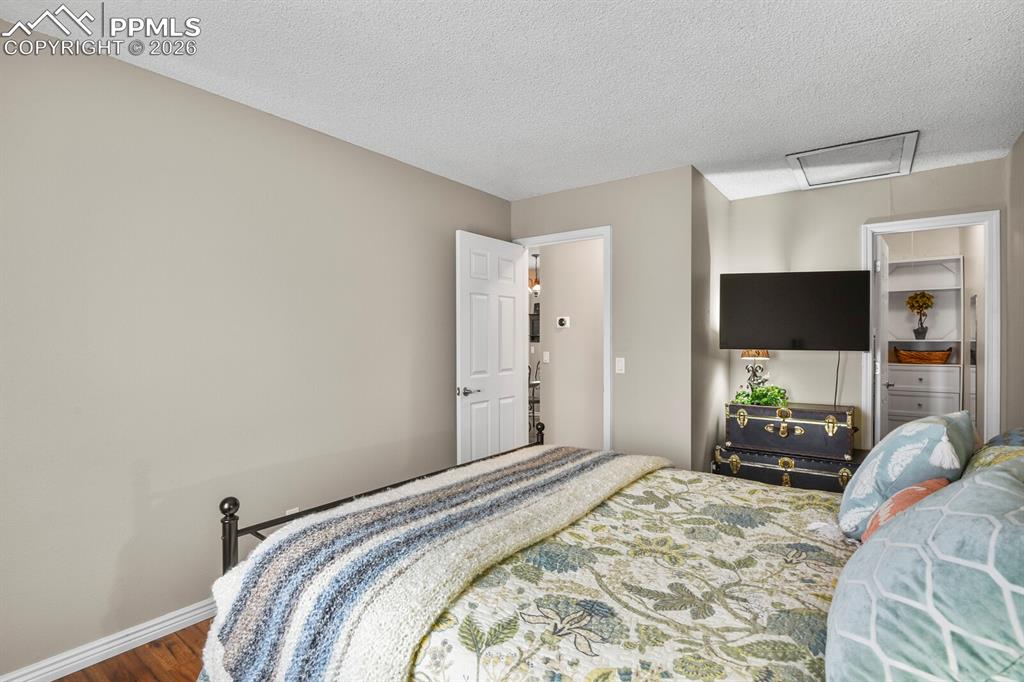 Bedroom with dark wood finished floors and a textured ceiling