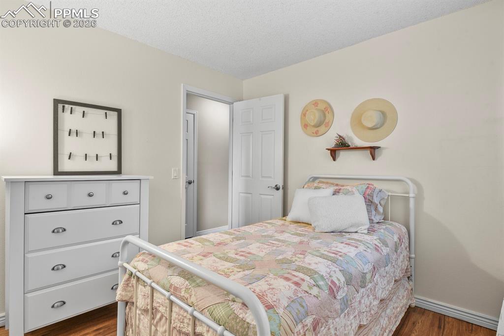 Bedroom with a textured ceiling and dark wood finished floors