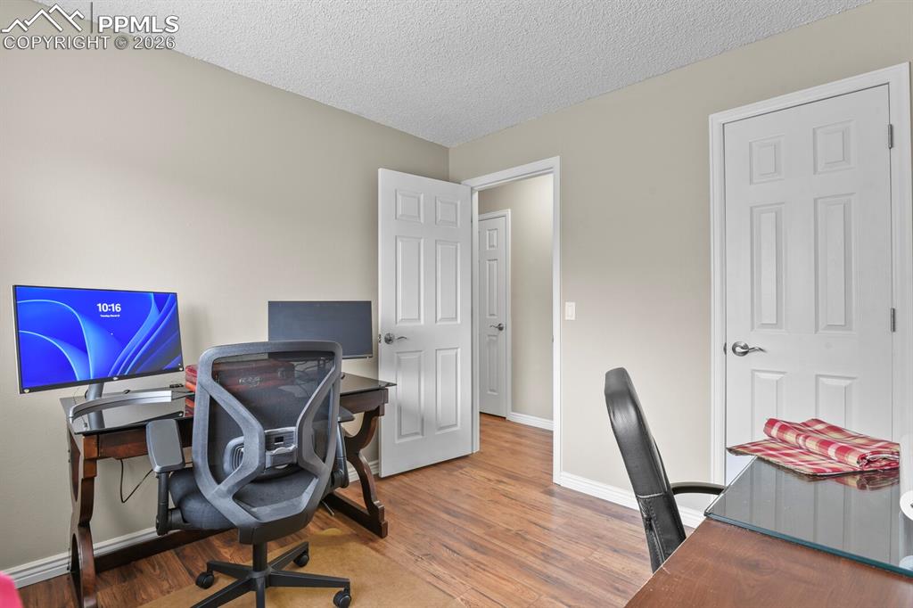 Office area featuring a textured ceiling and wood finished floors