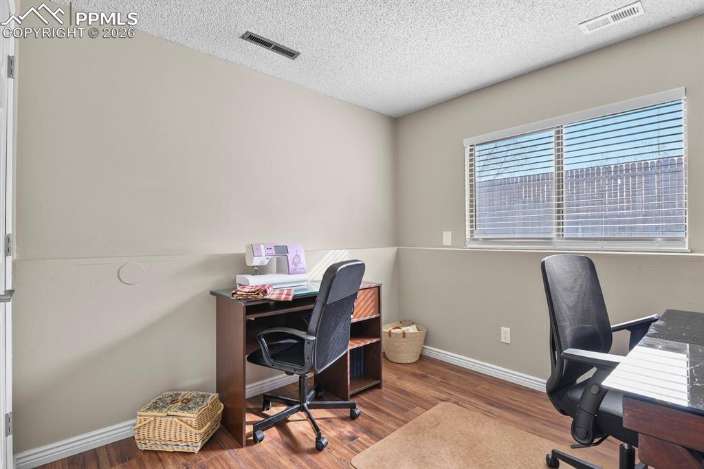 Office space featuring dark wood-type flooring and a textured ceiling