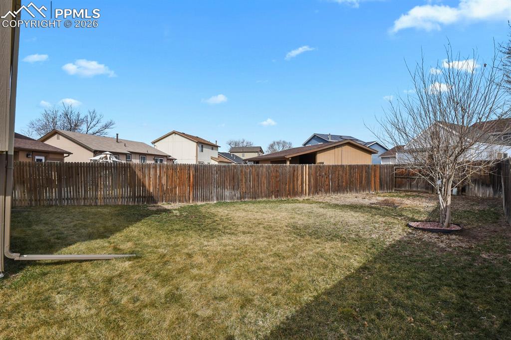 Fenced backyard featuring a residential view