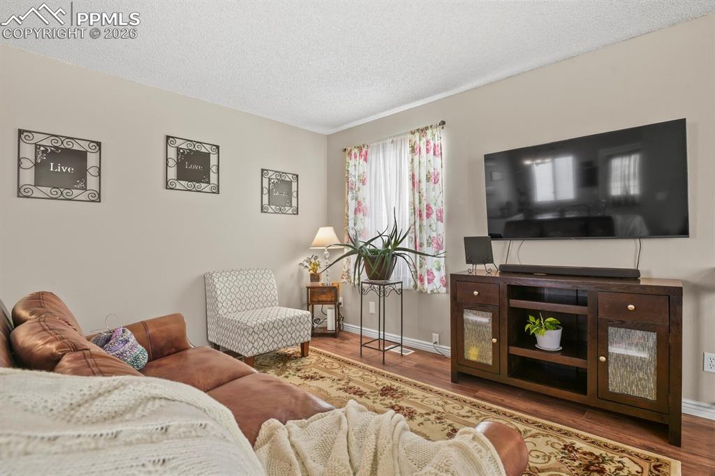 Living area with a textured ceiling and wood finished floors