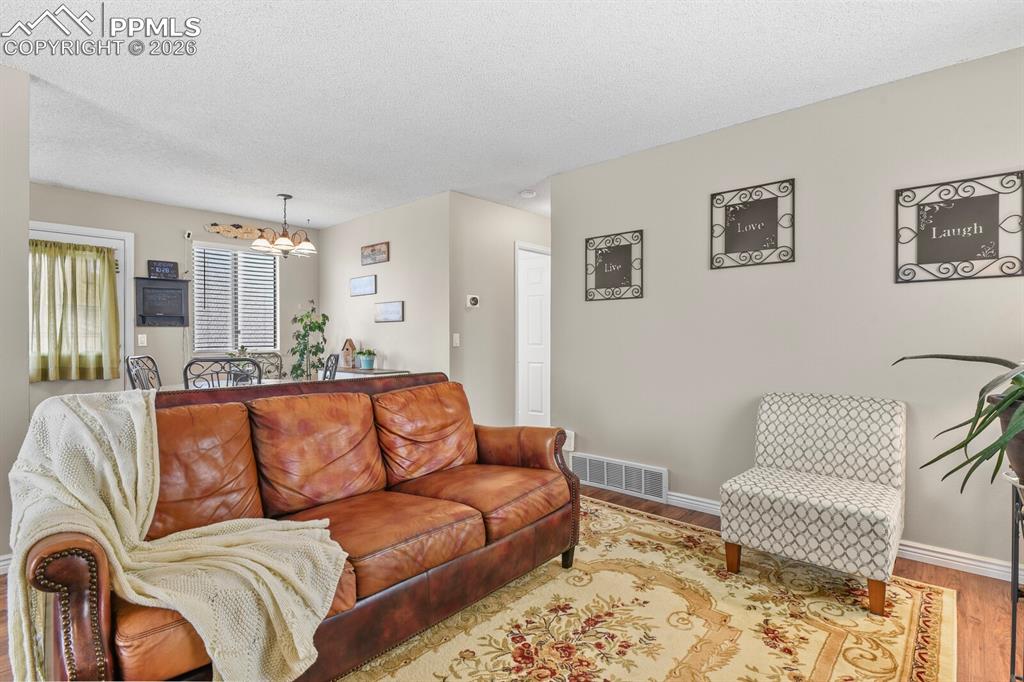 Living area with a chandelier and wood finished floors
