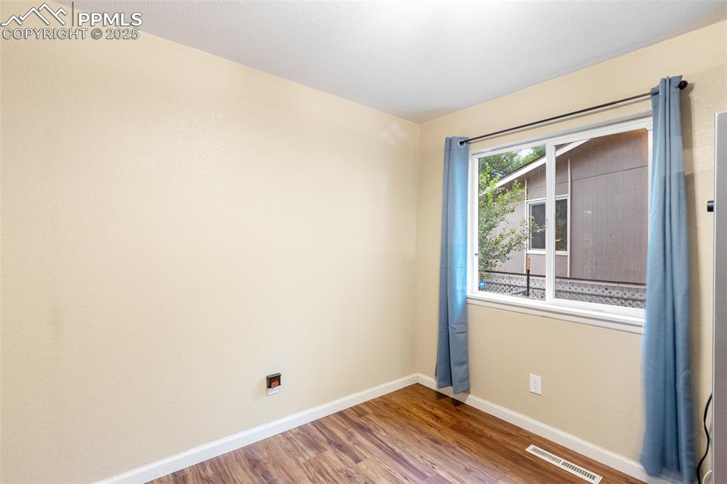 Unfurnished room with baseboards and wood finished floors