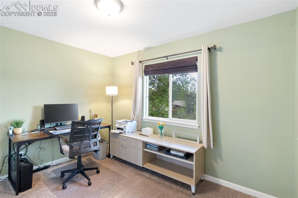 Office space with light carpet and baseboards