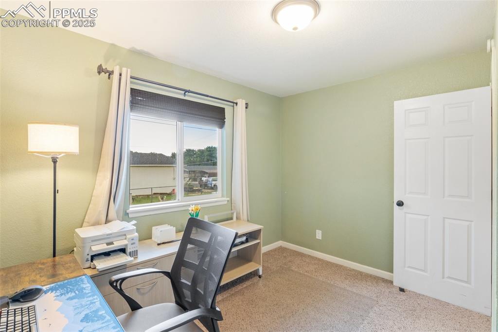 Carpeted home office with baseboards