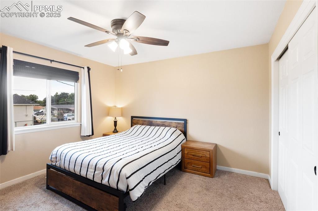 Carpeted bedroom featuring a closet and ceiling fan