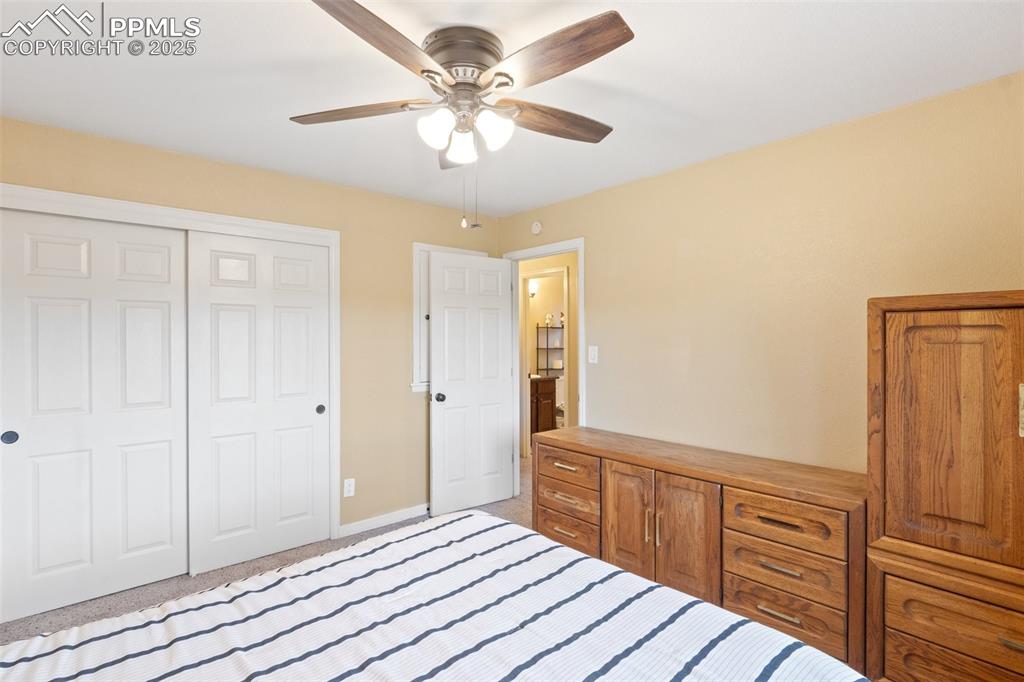 Bedroom with a closet, light carpet, and ceiling fan