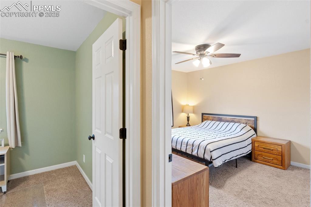 Carpeted bedroom featuring baseboards and a ceiling fan