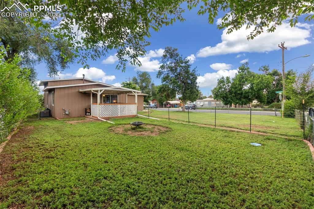 Fenced backyard with a fire pit