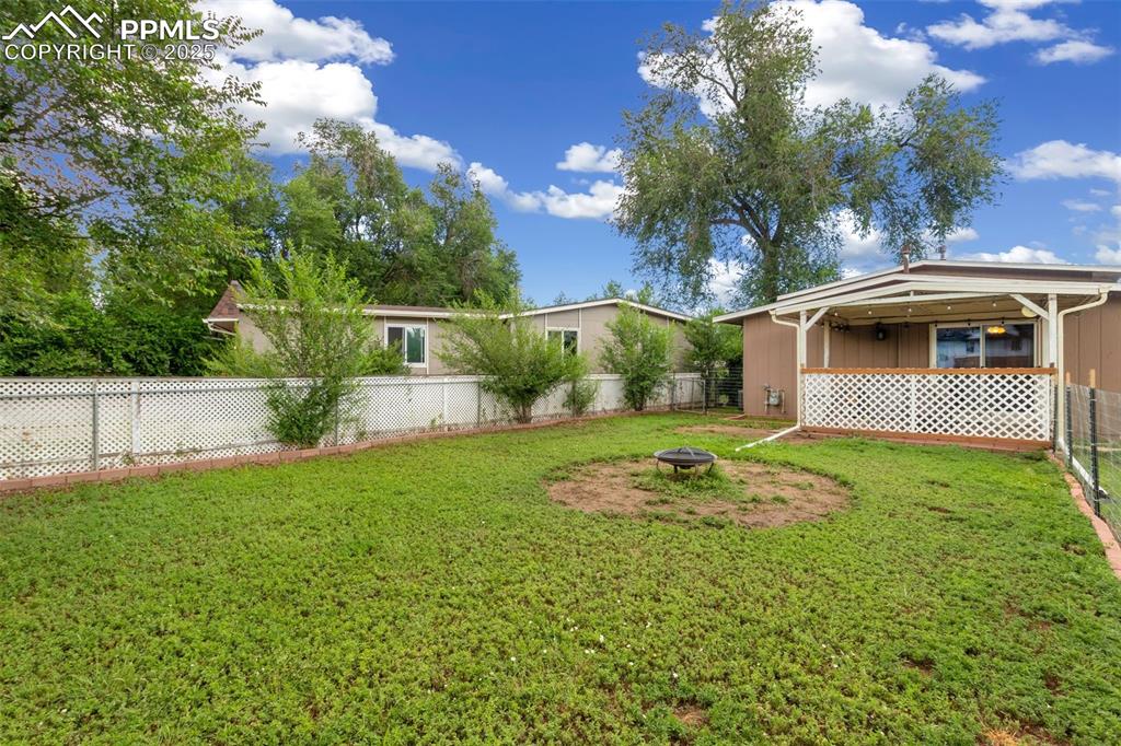 Fenced backyard featuring a fire pit