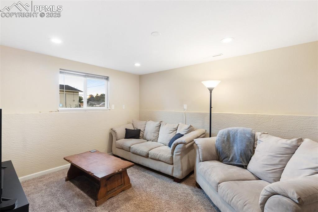 Living area with carpet floors and recessed lighting