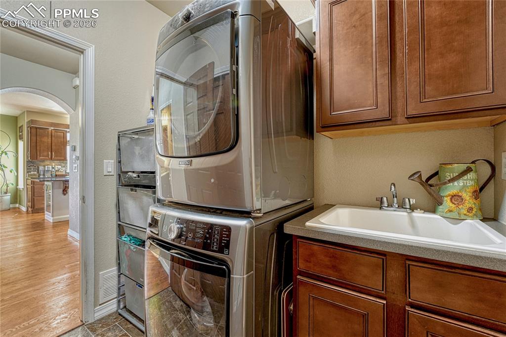 Main-level laundry room with utility sink and included Maytag washer and dryer