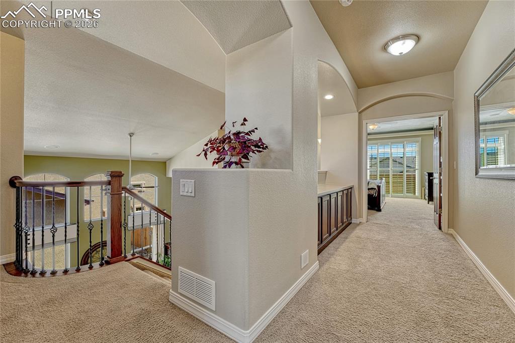 Open catwalk hallway leading to the primary suite