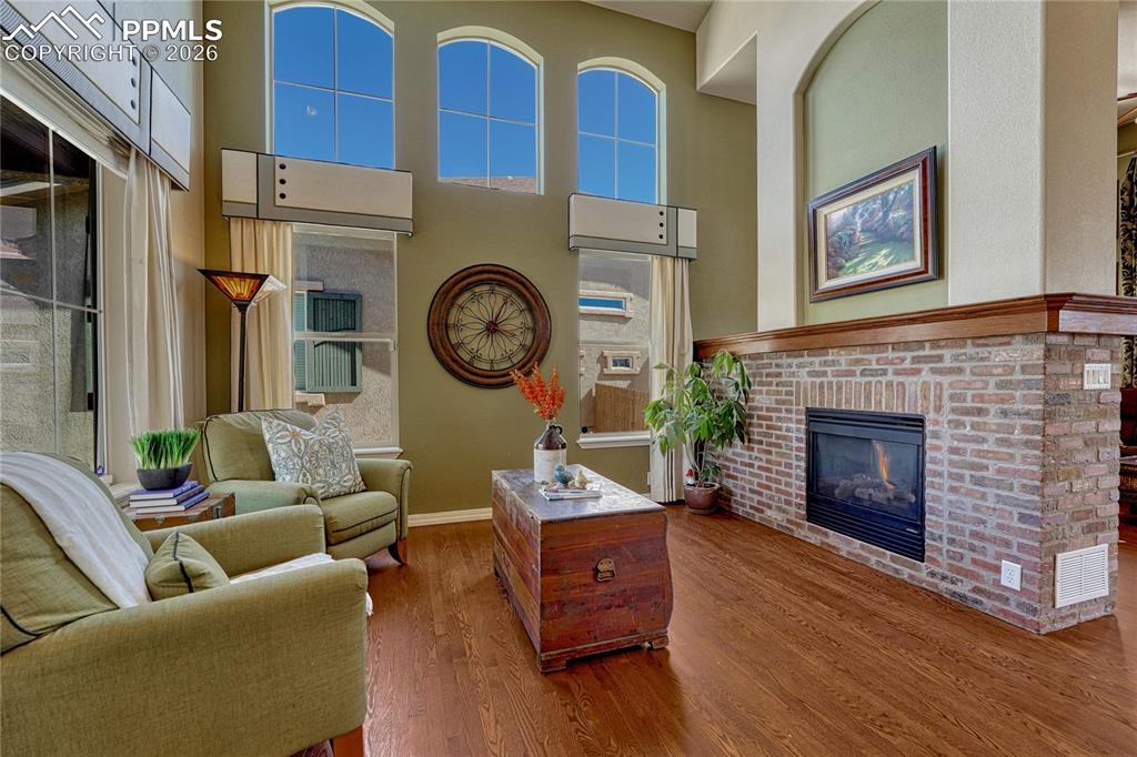 Tall ceilings and a two sided brick, gas log fireplace
