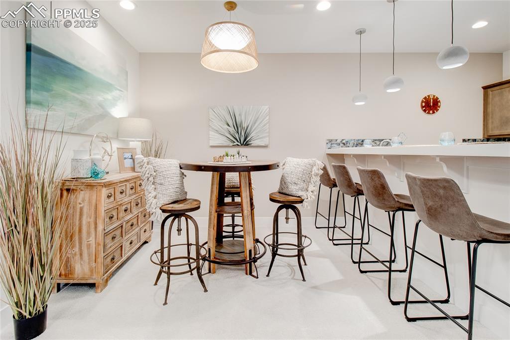 Bar featuring hanging light fixtures and recessed lighting