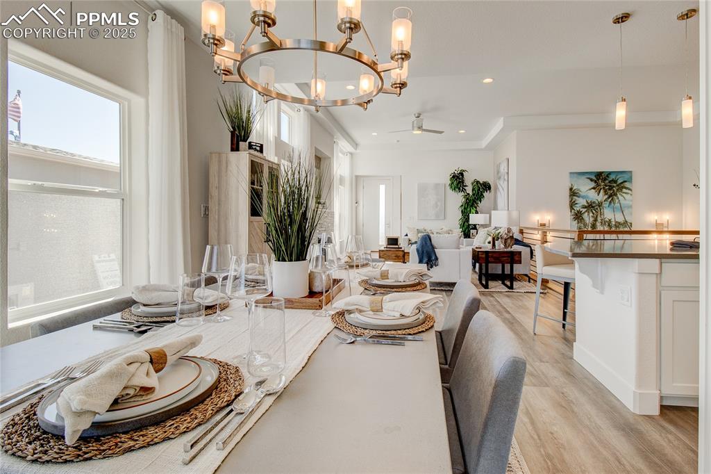 Dining area with a chandelier, light wood-type flooring, a ceiling fan, recessed lighting, and crown molding
