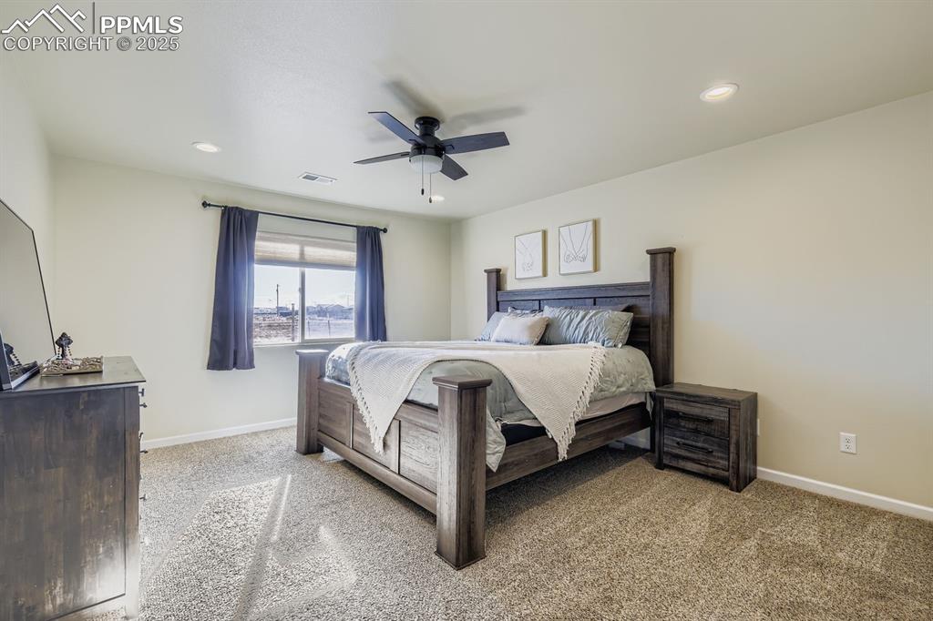 Bedroom with light carpet, a ceiling fan, and recessed lighting