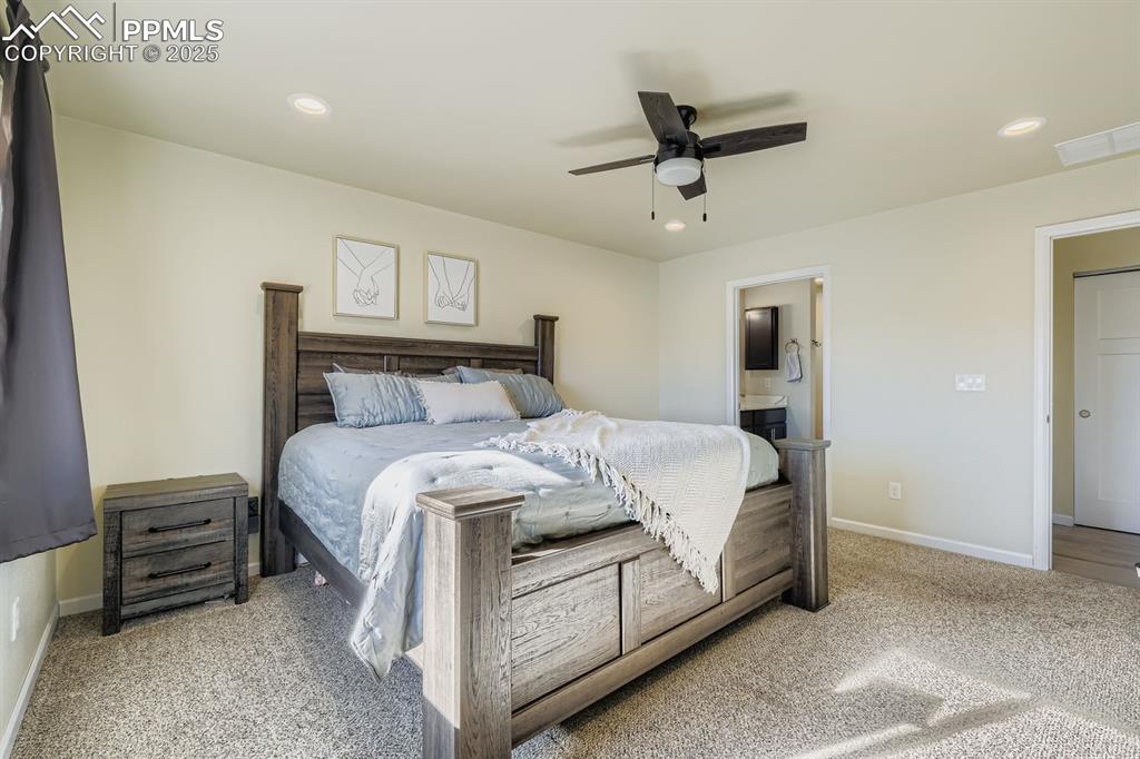 Bedroom featuring a ceiling fan, recessed lighting, light colored carpet, and ensuite bath