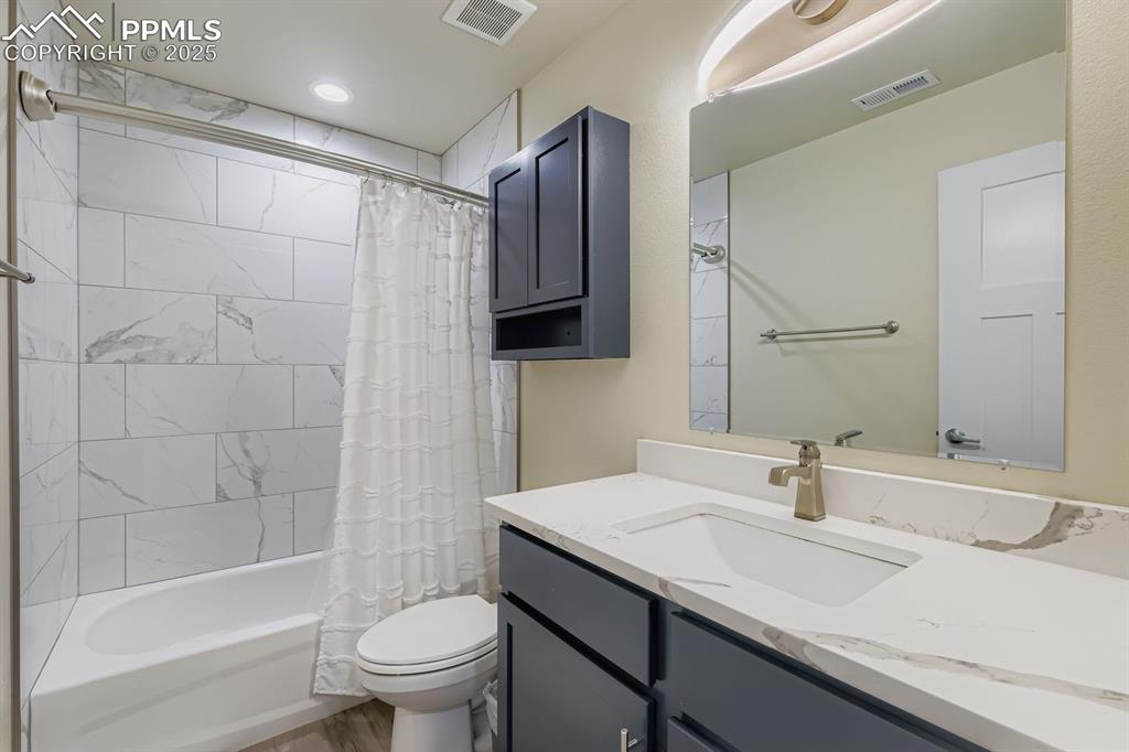Full bathroom featuring shower / bathtub combination with curtain and vanity